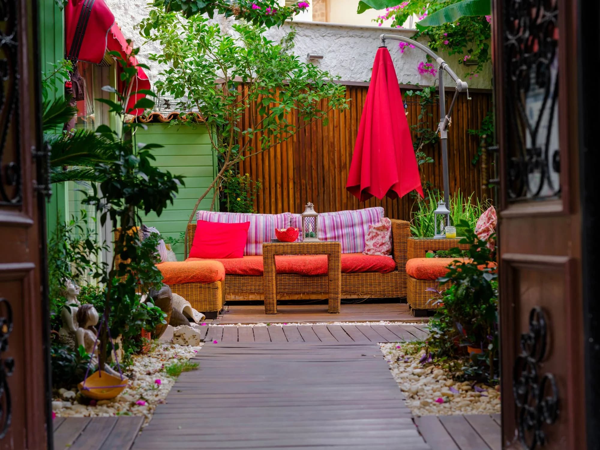 A vibrant small outdoor patio with wicker furniture and bright cushions