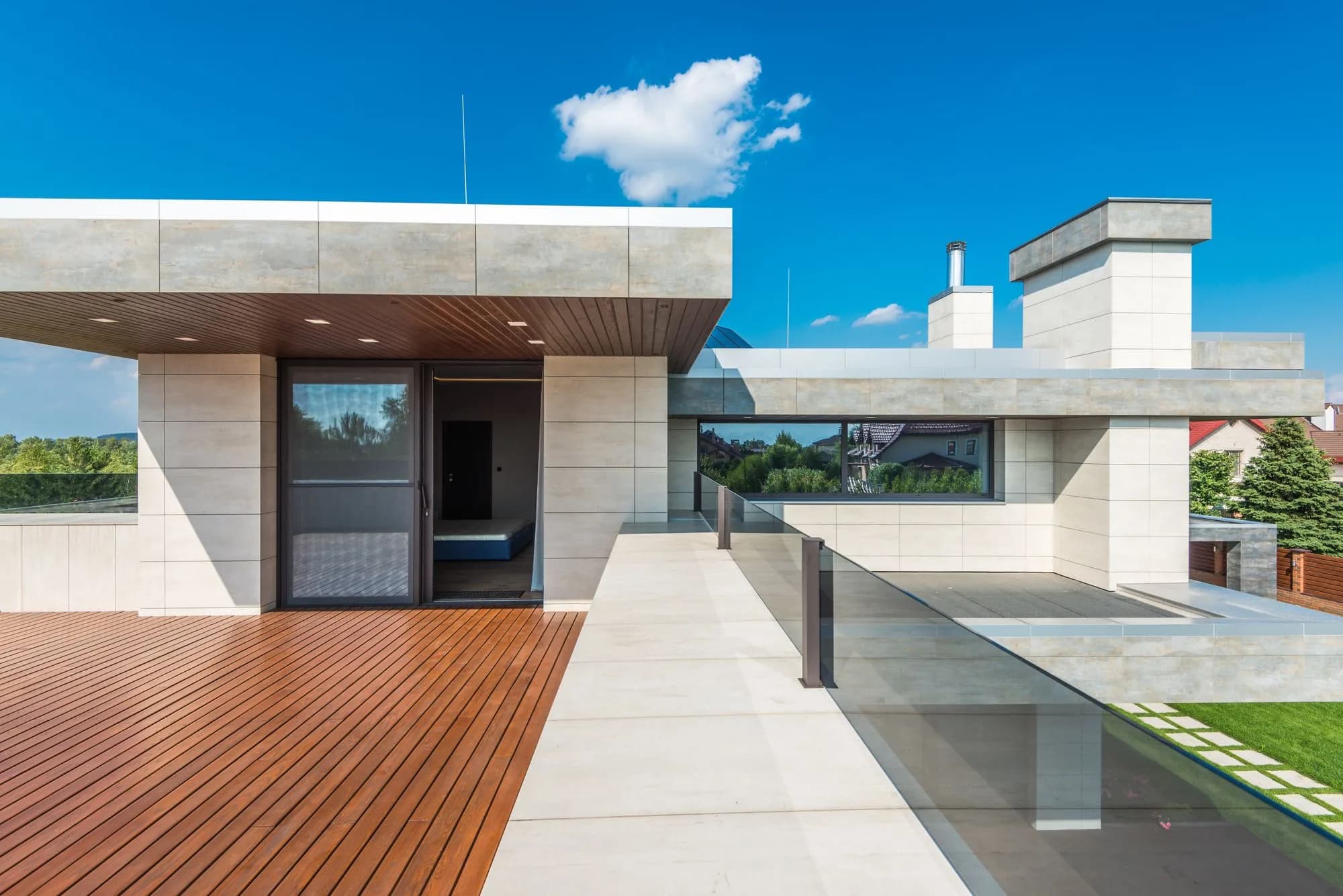 A sleek modern composite deck terrace with clean board lines set against a bright blue sky